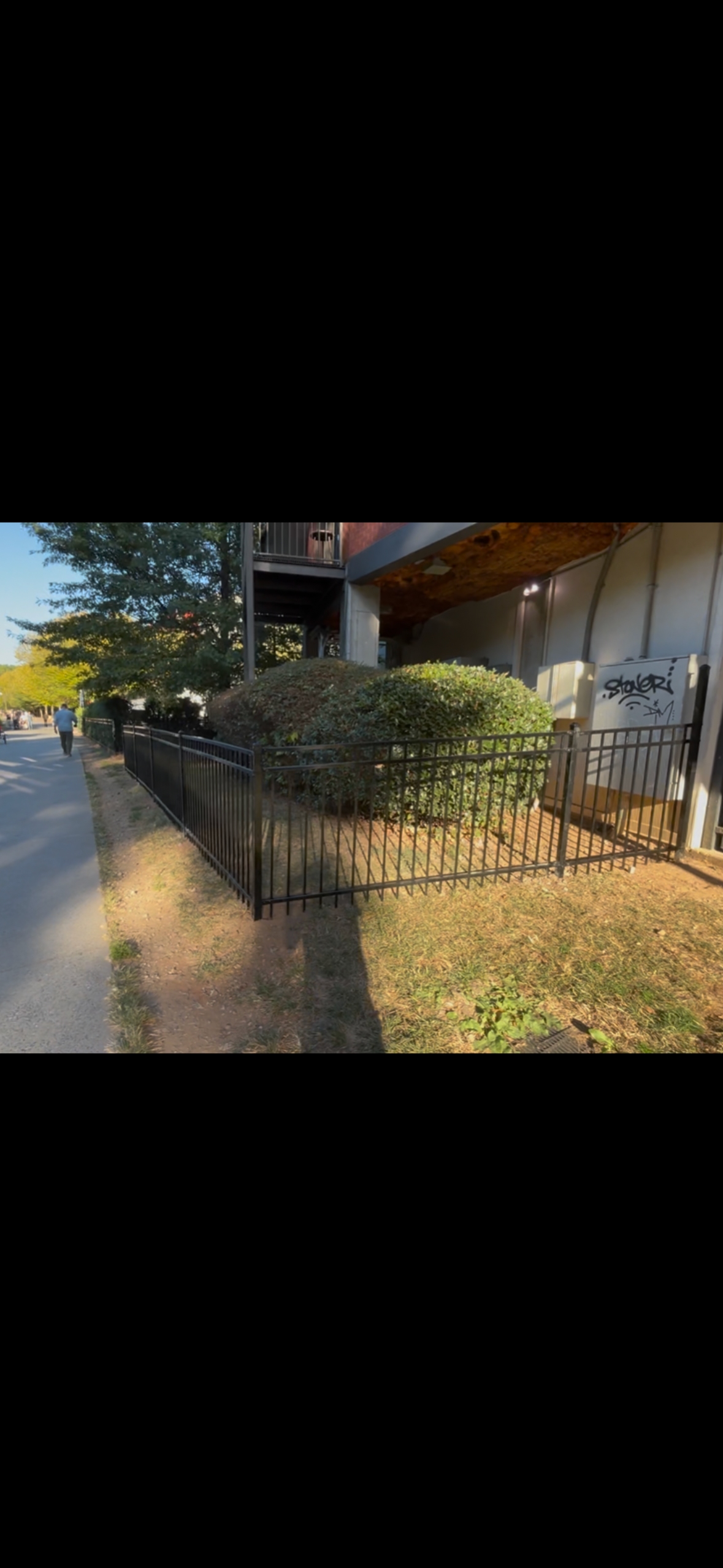Black powder-coated aluminum picket fence installed by Fleming Fencing along a commercial property in north Georgia